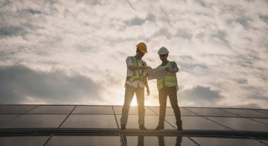 Servis mühendisi hasar görmüş bir parça var mı diye çatıdaki güneş hücresini kontrol ediyor. Mühendis işçisi güneş paneli kuruyor. Temiz enerji kavramı.