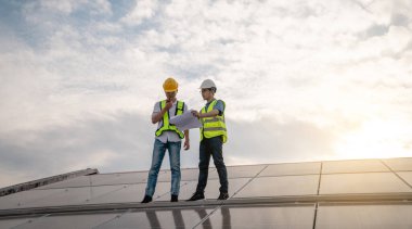 Servis mühendisi hasar görmüş bir parça var mı diye çatıdaki güneş hücresini kontrol ediyor. Mühendis işçisi güneş paneli kuruyor. Temiz enerji kavramı.
