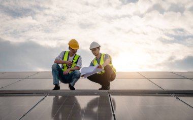 Servis mühendisi hasar görmüş bir parça var mı diye çatıdaki güneş hücresini kontrol ediyor. Mühendis işçisi güneş paneli kuruyor. Temiz enerji kavramı.