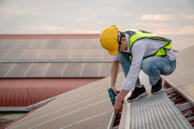 Servis mühendisi hasar görmüş bir parça var mı diye çatıdaki güneş hücresini kontrol ediyor. Mühendis işçisi güneş paneli kuruyor. Temiz enerji kavramı.