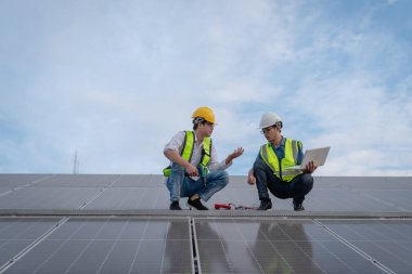 Servis mühendisi hasar görmüş bir parça var mı diye çatıdaki güneş hücresini kontrol ediyor. Mühendis işçisi güneş paneli kuruyor. Temiz enerji kavramı.