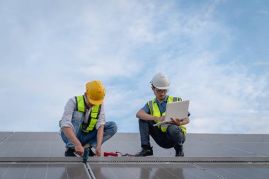 Servis mühendisi hasar görmüş bir parça var mı diye çatıdaki güneş hücresini kontrol ediyor. Mühendis işçisi güneş paneli kuruyor. Temiz enerji kavramı.