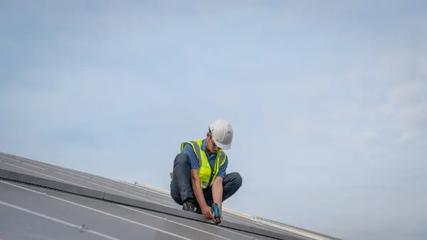 Service engineer checking solar cell on the roof for maintenance if there is a damaged part. Engineer worker install solar panel. Clean energy concept.