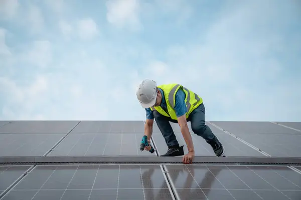 屋根の太陽電池を点検するサービスエンジニア 損傷した部分があれば維持のため エンジニアの労働者は太陽電池パネルを取付けます クリーンエネルギーコンセプト ロイヤリティフリーのストック画像