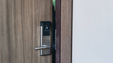 Oteldeki açık kapı için elektronik kart anahtarı. Kapıyı kilitleyip açmak için akıllı kart anahtarı. Güvenlik sistemleri ve koruma kavramı.