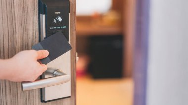 Oteldeki açık kapı için elektronik kart anahtarı. Kapıyı kilitleyip açmak için akıllı kart anahtarı. Güvenlik sistemleri ve koruma kavramı.