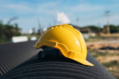 Sarı mühendis, kaskını dairesel su borusuna taktı. İnşaat ve Petrol Doğal Gaz ve Yakıt Taşımacılık kavramı.