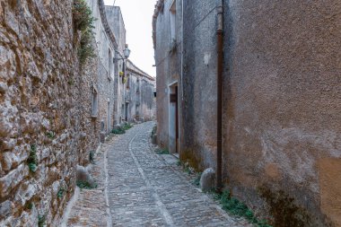 Bir ortaçağ Sicilya köyünün sokaklarını ve köşelerini keşfediyorlar.