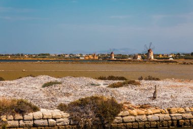 Batı Sicilya 'nın kıyı manzarası adanın zengin tarihi ve doğal kaynaklarının özünü yakalayan geleneksel tuz tavaları ve yel değirmenleriyle doludur..