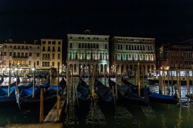 Venedik 'te demirlemiş muhteşem gondollar, arka planda ikonik Venedik kiliseleri