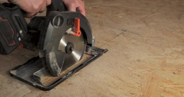 用圆锯切割胶合板的工人的特写镜头 用框架技术建造一座新的木制房屋 — 图库视频影像