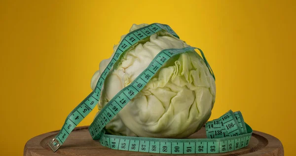 The Cabbage and the measurement tape are spinning. Sports nutrition, fitness and diet concept.