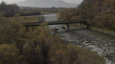 Old railway bridge over a river. Drone flight over bridge of old narrow gauge railway