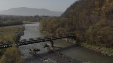Old railway bridge over a river. Drone flight over bridge of old narrow gauge railway