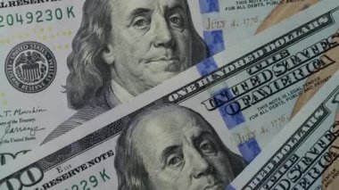 Fragment of one hundred dollar bills rotates close-up. High-resolution view of USD currency. Business, investment, fiat money, finance. Cash money background.