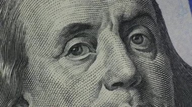 Fragment of one hundred dollar bill rotates close-up. 100 US banknote spinning in extreme macro. High-resolution view of USD currency. Business, investment, fiat money, finance. Cash money background.