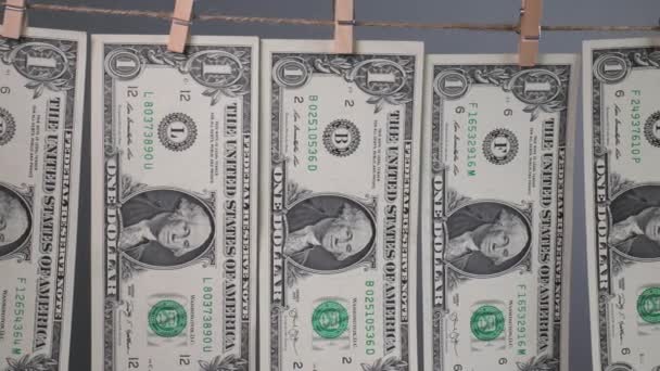 一块钱的钞票在灰色背景的衣针绳上晒干了 美元的金融概念 洗钱概念 — 图库视频影像