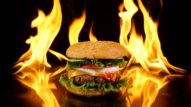 Ateşin arka planında nefis bir burger. Lezzetli burger, taze lahana, soğan, domates ve ızgara biftek. Fast food