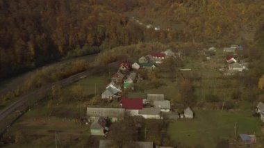 Sonbaharda dağlardaki bir köyün üzerinde bir dron uçuyor.