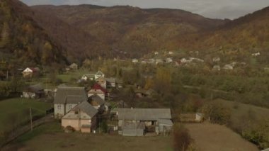 Sonbaharda dağlardaki bir köyün üzerinde bir dron uçuyor.