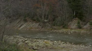 İnsansız hava aracı sonbaharda dağlarda, kırsal bölgede nehrin üzerinde uçar.