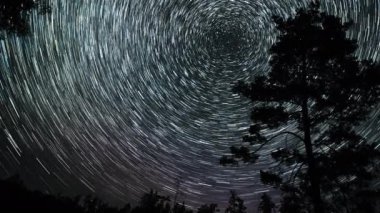 Gece gökyüzünde Yıldız 'ın zaman atlaması. Yıldızlar bir kutup yıldızının etrafında döner. 4K