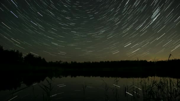 夜空の星のトレイルの時間の経過は湖の上に 星は極星の周りを移動する エピックビデオ — ストック動画