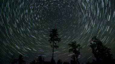 Gece gökyüzünde Yıldız 'ın zaman atlaması. Yıldızlar bir kutup yıldızının etrafında döner. 4K