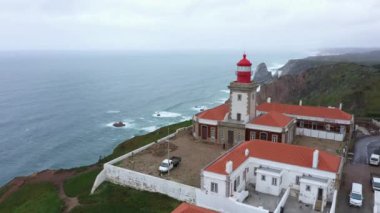 Cape Roca Cabo da Roca 'daki deniz fenerinin havadan görünüşü - Portekiz, Avrupa kıtasının en batı noktası. Atlantik Okyanusu 'nun üzerinde uçan insansız hava aracı güzel takımadalar oluşturur. 4k