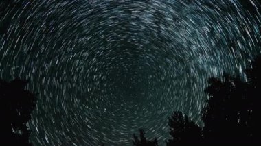 Gece gökyüzünde Yıldız 'ın zaman atlaması. Yıldızlar bir kutup yıldızının etrafında döner. 4K