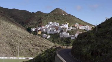 İspanyol Kanaryaları 'ndaki Tenerife adasındaki eski bir volkanın yamacındaki küçük bir köyün havadan görünüşü. 4K