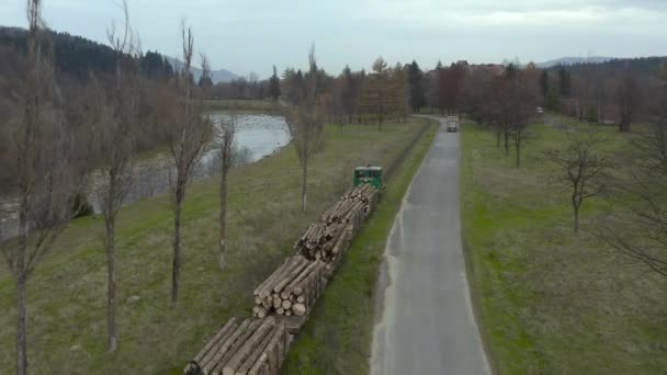 古い狭軌鉄道に沿って木材を運ぶ貨物列車の航空写真 ウクライナ カルパチアの木材収穫産業 — ストック動画