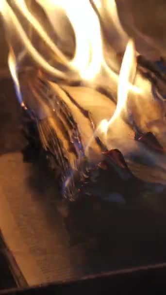 開かれた本が燃えている 明るい炎 暗闇の古い出版物に紙を燃やした ブックバーニング 検閲コンセプト スローモーション クローズアップ 垂直ビデオ — ストック動画