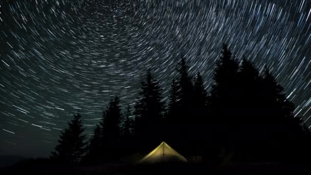 Tiden Går För Kometformade Stjärnspår Natthimlen Ovanför Ett Glödande Tält — Stockvideo