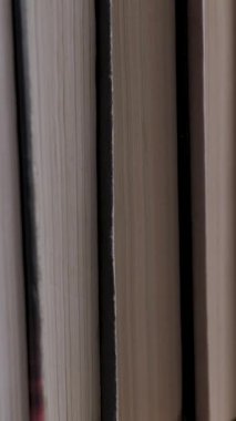 Kitap rafları kütüphanede. Büyük bir kitapçıda raflarda organize edilmiş birçok kitabı kapat. Öğrenme, okuma ve bilgi kavramı. Dikey video