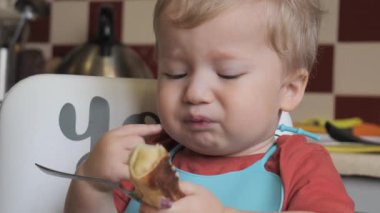 Küçük bir çocuğun kahvaltısını yakından çekerken, çocuk kendini yemeye çalışır, mutlu bir çocukluk. Yüksek kalite 4K görüntü
