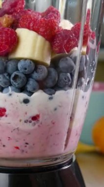 Sağlıklı Çiğ Vegan Ahududu Yabanmersinli Muz Smoothie kokteyli hazırlıyorum. Sağlıklı organik gıda, yakın çekim, dikey görüntü