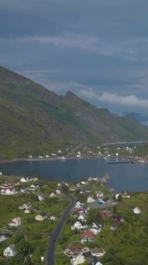 Deniz kıyısının ve küçük balıkçı köylerinin havadan görünüşü. Lofoten Adaları. Norveç. dikey görüntüler