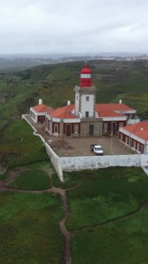Cape Roca Cabo da Roca 'daki deniz fenerinin havadan görünüşü - Portekiz, Avrupa kıtasının en batı noktası. Atlantik Okyanusu kıyısında uçan insansız hava aracı güzel takımadalar oluşturur.