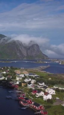 Norveç 'in Lofoten adalarındaki Resimli balıkçı kasabası Reine' in hava manzarası güneşli yaz gününde popüler turizm beldesi, dikey görüntüler