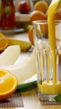 Kavun muzlu meyve suyu taze meyvelerin arka planında bir bardağa doldurulur. Meyve kokteyli yemek için hazır. Sağlıklı ve vejetaryen gıda konsepti. Yakın çekim, dikey görüntü