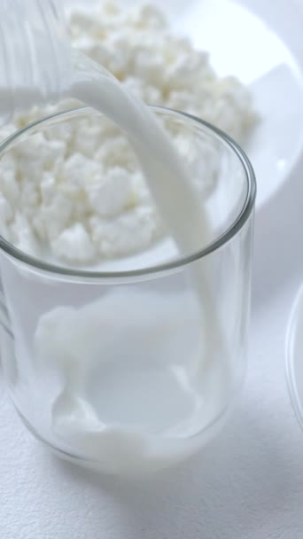 軽い背景にボトルからガラスにミルクを注ぐ 朝食メニューとデザート 健康と乳製品のコンセプト 閉じる 垂直の映像 — ストック動画