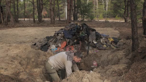 一个工人清理了森林中的垃圾 把垃圾从洞里扔到一堆垃圾上 安全生态概念 — 图库视频影像