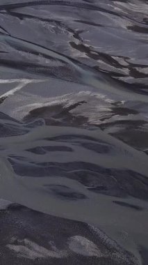 Buzul nehir deseninin havadan görünüşü. İzlanda 'nın inanılmaz doğası. Güzel bir doğa geçmişi var. dikey görüntüler