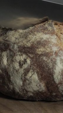 Ev yapımı çavdar ekmeği dilimlemek tahta tahtada keskin bir bıçakla yakın plan dikey görüntüler.