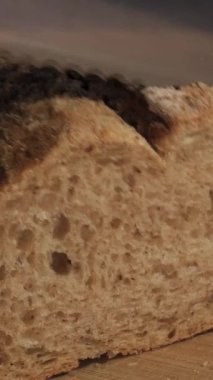 Ev yapımı çavdar ekmeği dilimlemek tahta tahtada keskin bir bıçakla yakın plan dikey görüntüler.