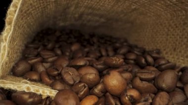 Video, çuval içinde kavrulmuş kahve çekirdeklerini gösteriyor. Kamera, Çuval Çuval 'dan çıkıyor. Kahve endüstrisi kavramı.