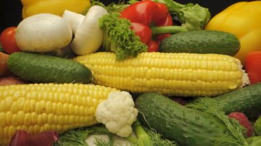 Bu video, dolmalık biber, domates, mısır, salatalık ve mantarlar da dahil olmak üzere çeşitli taze sebzelerin yakın plan görüntülerini sergiliyor. Canlı renkler bu yiyeceklerin doğal güzelliğini vurgular..