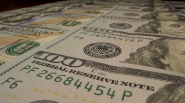 Benjamin Franklin 'in portresini ve para biriminin detaylarını gösteren 100 dolarlık banknotların yakın plan çekimi. Hareket eden kamera