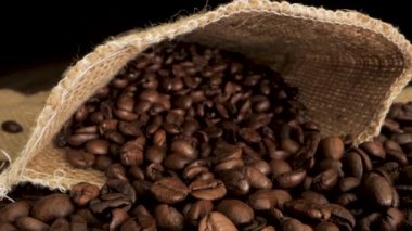 Video, çuval içinde kavrulmuş kahve çekirdeklerini gösteriyor. Çuvalın doğal dokusu ve kahve çekirdeklerinin pürüzsüz, zengin rengi görsel olarak çekici bir kontrastlık yaratır..